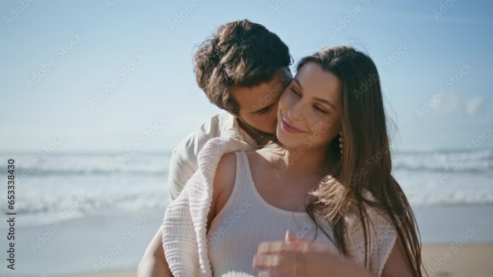 Affectionate pregnant couple posing on sunny beach close up. Spouses relaxing Affectionate pregnant couple posing on sunny beach close up. Spouses relaxing
