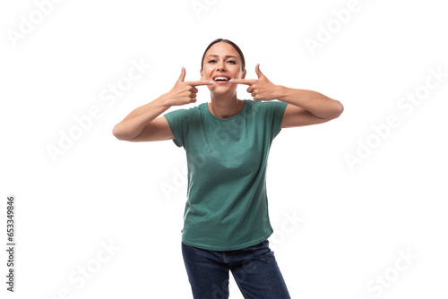 young joyful positive black-haired woman in a green basic t-shirt reports the news on a white background with copy space