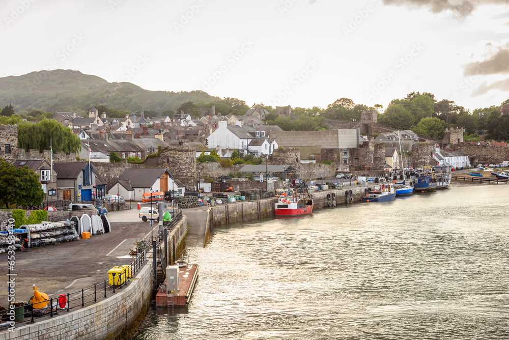View of fishing harbour in a walled coastal town at sunset in summer View of fishing harbour in a walled coastal town at sunset in summer