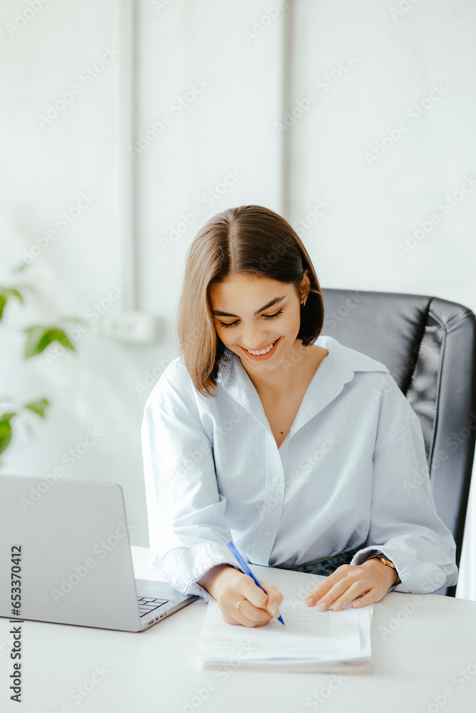 Verstical shot of a business woman working on some papers in the office. Verstical shot of a business woman working on some papers in the office.
