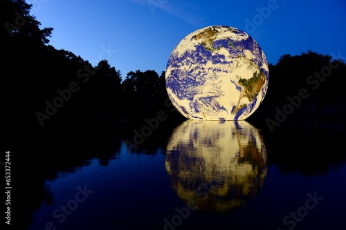 Floating Earth, Jersey, U.K. Queens valley reservoir. A floating 10 metre ball of our home planet, showing the fragility of our planet especially today during climate change.