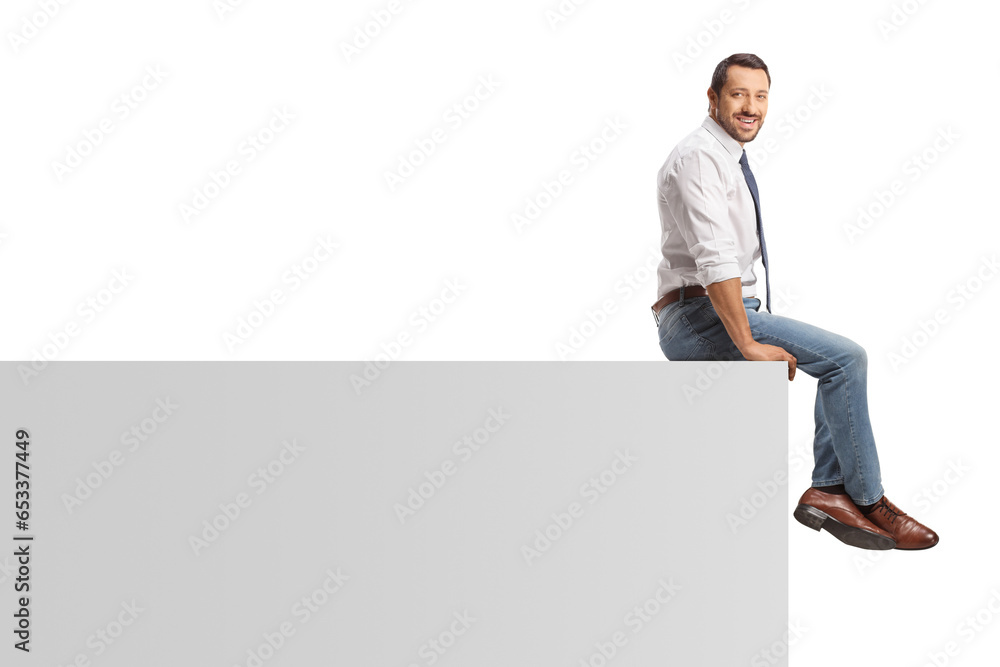 Young professional man sitting on a white wall Young professional man sitting on a white wall