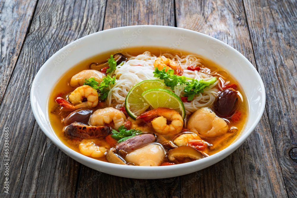 Yunnan hot pot - Chinese soup with shrimps on wooden table
Yunnan hot pot - Chinese soup with shrimps on wooden table