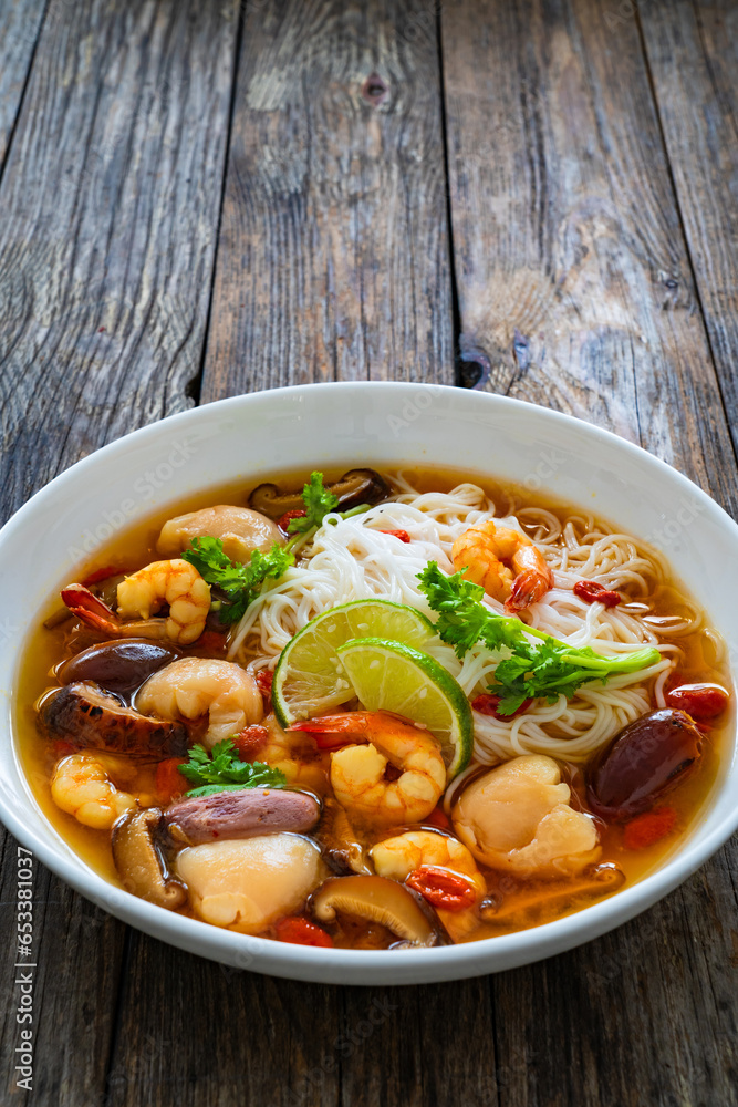 Yunnan hot pot - Chinese soup with shrimps on wooden table
Yunnan hot pot - Chinese soup with shrimps on wooden table