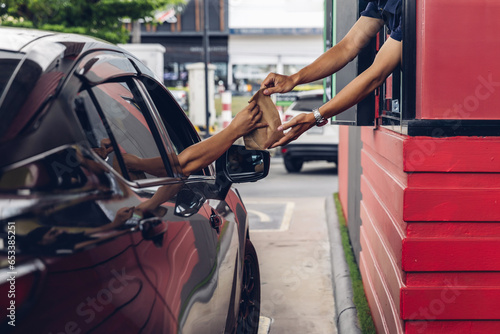 Fotografering Hand Man in car receiving coffee in drive thru fast food restaurant