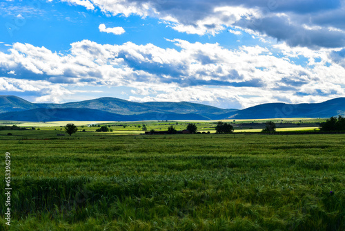 Mountain ridge far behind the agrucltural fields with beautiful scenic view in springtime