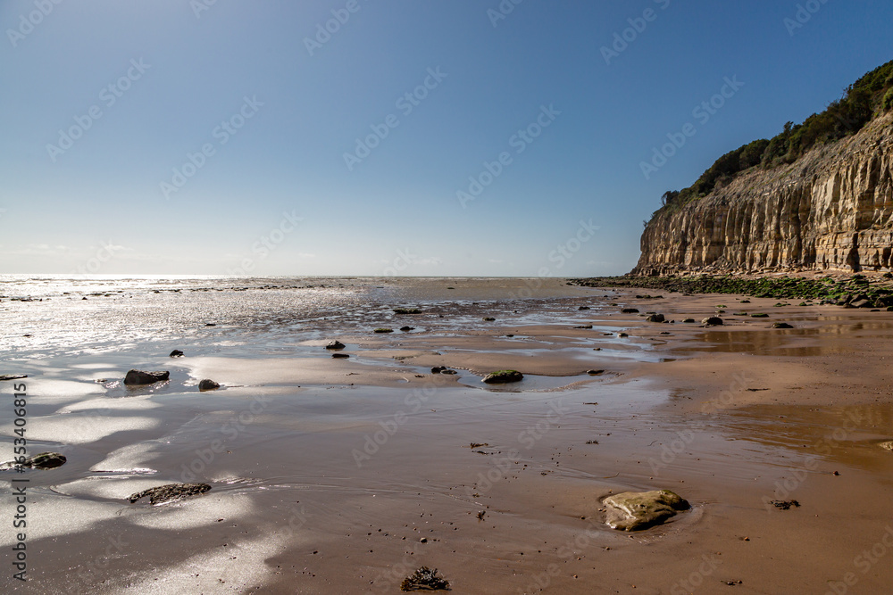 A view along Pett Level beach towards the cliffs, at low tide A view along Pett Level beach towards the cliffs, at low tide