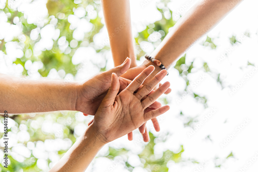 Fototapeta premium image from below of a group of unrecognizable friends from the lgbt community joining hands together celebrating outdoors
