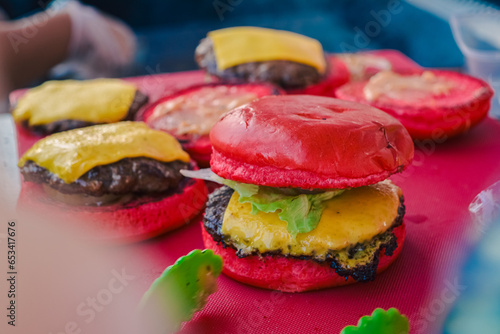 red burger on the table with a blurred burger background (ID: 653417676)