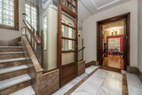 Residential apartment building with vintage elevator and access to housing with hall full of vintage furniture