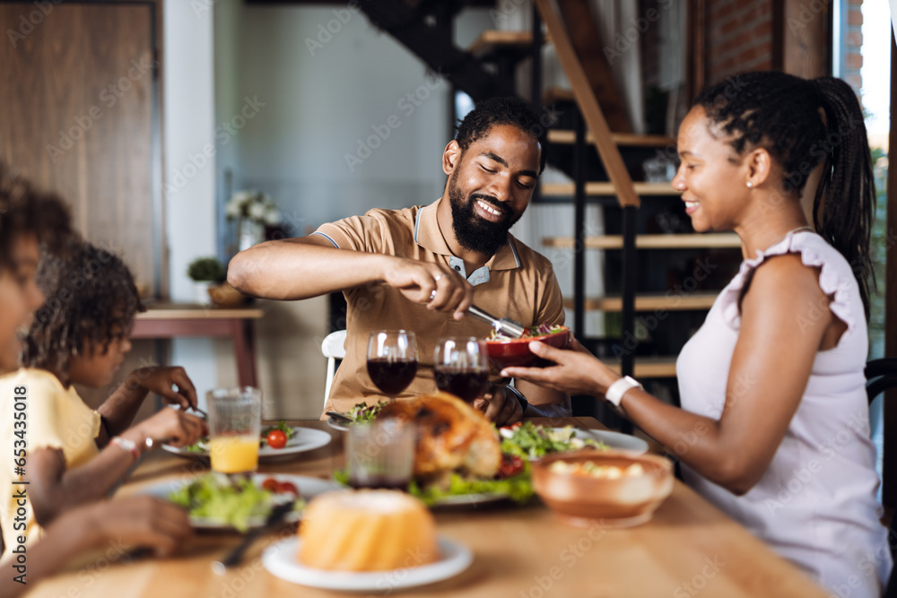 Happy African American family having Thanksgiving dinner at dining table