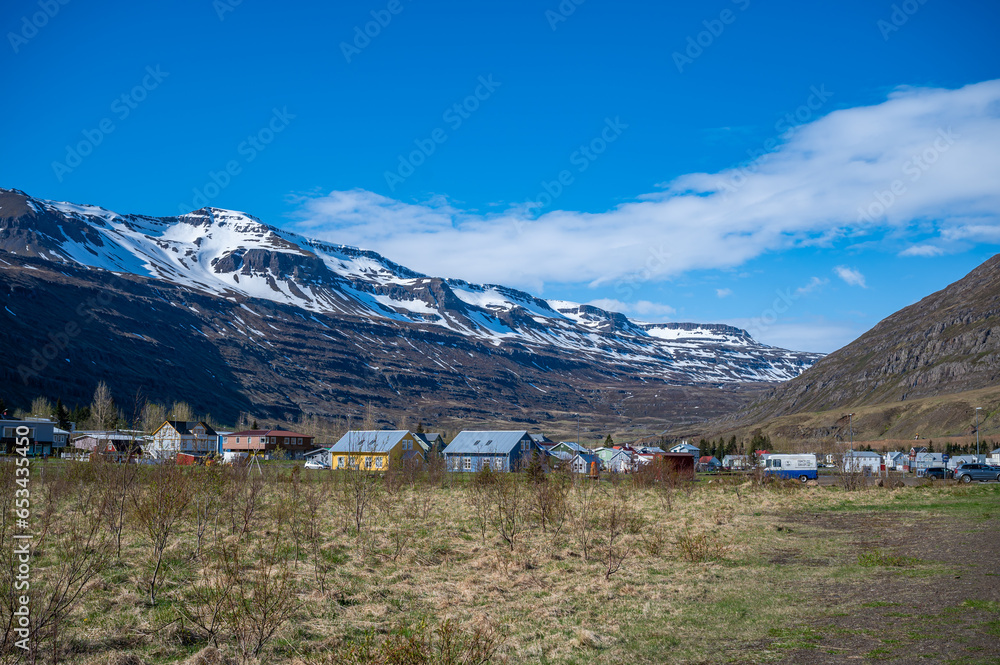 Cityscape of Seydisfjordur, Iceland, colorful houses in front of a snow mountain during great weather