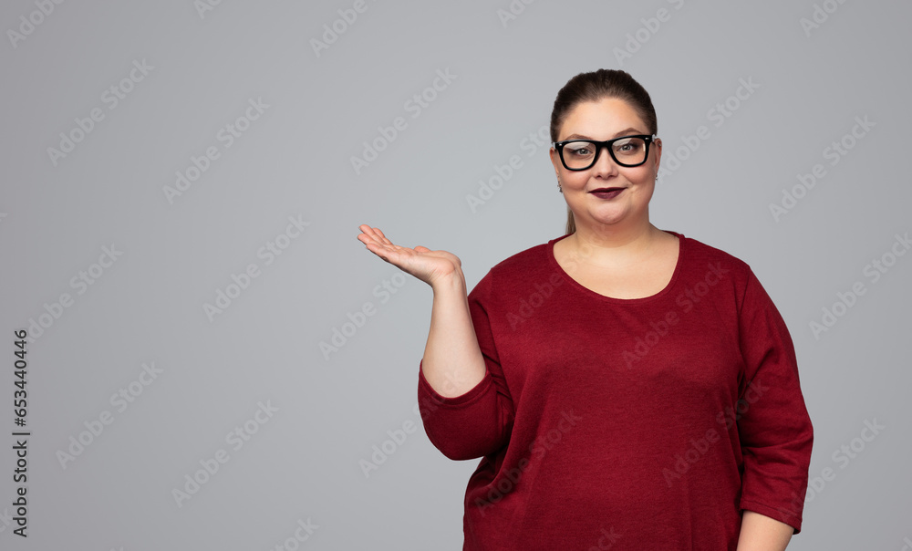 Plus size woman in eyeglasses showing empty space Plus size woman in eyeglasses showing empty space