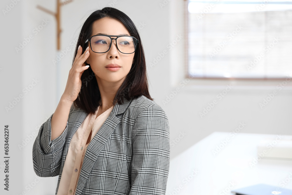 Beautiful Asian businesswoman in stylish eyeglasses in office Beautiful Asian businesswoman in stylish eyeglasses in office