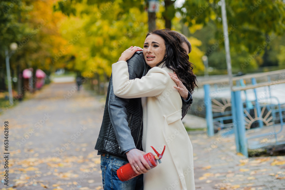 A man hugs a pregnant woman. A man uses a fire extinguisher to determine the sex of his child. Gender party. Happy parents A man hugs a pregnant woman. A man uses a fire extinguisher to determine the sex of his child. Gender party. Happy parents