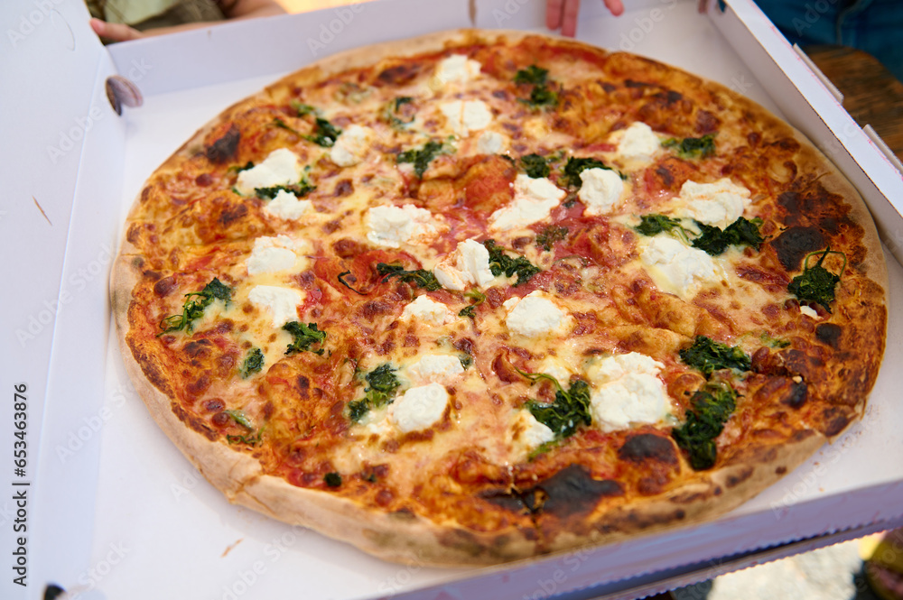 Neapolitan homemade pizza margarita from the brick oven in a disposable cardboard box. Traditional Pizza Margherita Neapolitan homemade pizza margarita from the brick oven in a disposable cardboard box. Traditional Pizza Margherita