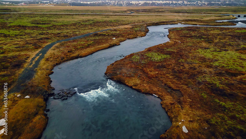 Beautiful oxarafoss waterfall panorama, drone shot of icelandic cascade running down of cliff. Huge water stream flowing and falling off massive rocky hills in iceland. Slow motion. photo