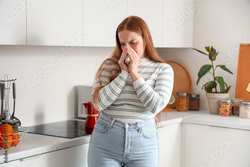 Allergic young woman sneezi...