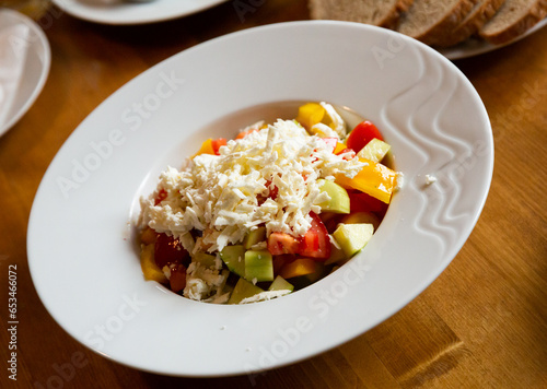 Dish of Balkan cuisine Shopska salad with cucumbers, tomatoes, bell peppers and brynza (salted sheep cheese)