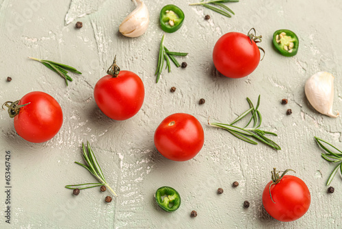 Composition with ripe cherry tomatoes, rosemary, jalapeno and peppercorn on color background
