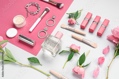 Composition with female accessories, cosmetics, makeup brushes and peony flowers on color background