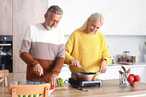 Mature couple cooking in kitchen