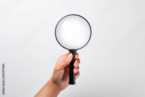Person holding magnifying glass in their hand. Can be used to illustrate concepts such as investigation, curiosity, or search for information