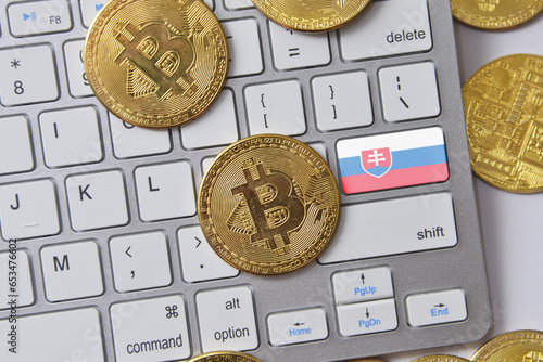 Photography national flag of slovakia on the keyboard with bitcoin coins on a grey background
