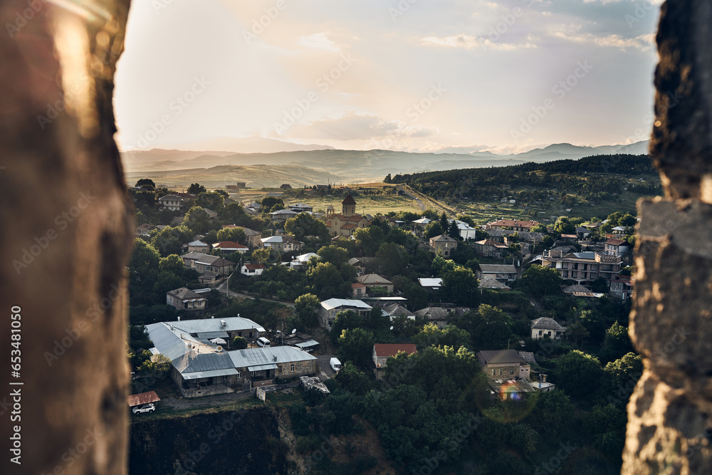  Akhaltsikhe (Rabati) Castle, medieval fortress built in the 9th century. Located in Akhaltsikhe city in southern Georgia.  Golden hour view of the village and mountains on the background 