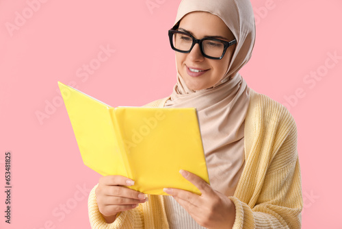 Young Muslim woman reading ...