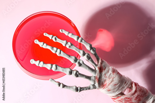 Skeleton hand with glass of...