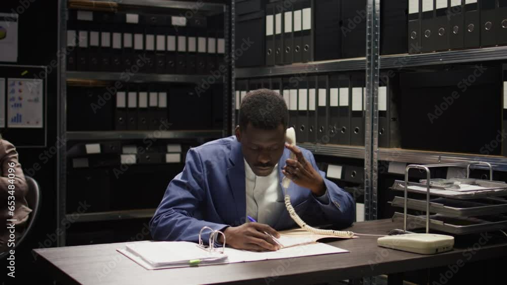 Black cop conducts a discreet investigation, analyses evidence, and makes important phone calls. African american law officer collects classified witness statements and information over the telephone. Black cop conducts a discreet investigation, analyses evidence, and makes important phone calls. African american law officer collects classified witness statements and information over the telephone.