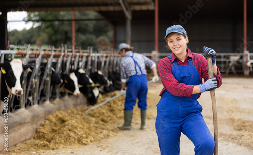 Portrait of positive female farm worker in a cowshed
