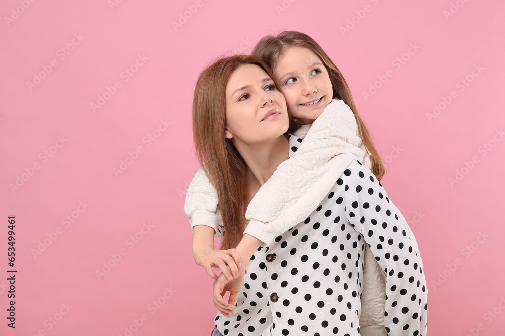 Portrait of mother and her cute daughter on pink background. Space for text Portrait of mother and her cute daughter on pink background. Space for text