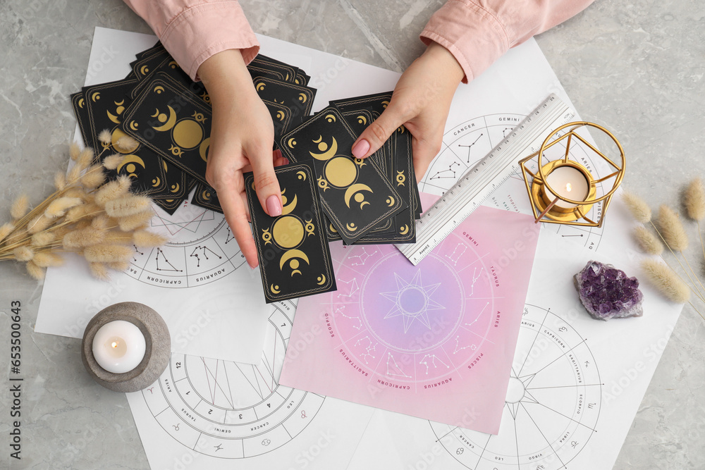 Fotografie Woman using tarot cards at table, top view