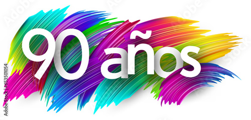 90 years at spanish paper word sign with colorful spectrum paint brush strokes over white.