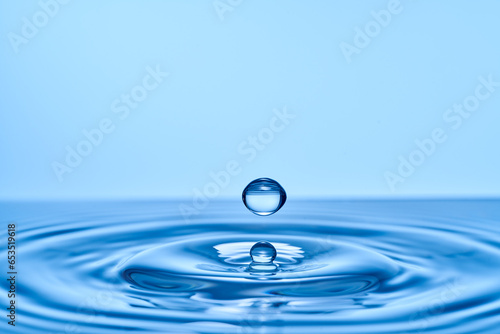 Group of water droplets fall and bounce on a water surface