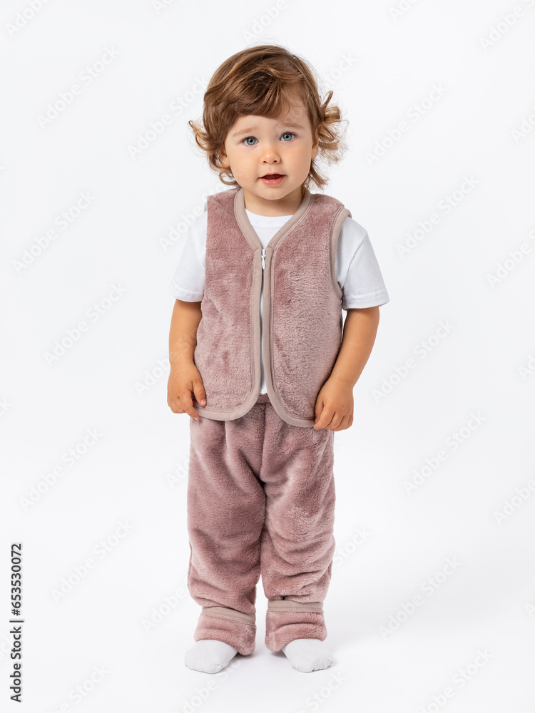 A toddler with curly hair expressively looks with big blue eyes directly into the camera. Dressed in a purple plush suit. A toddler with curly hair expressively looks with big blue eyes directly into the camera. Dressed in a purple plush suit.