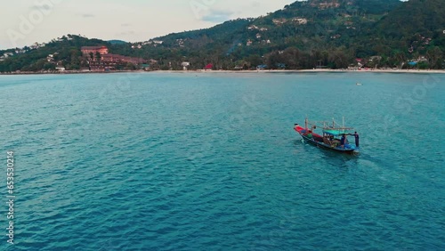 Aerial view of fishermen's boats in harbor of Mexico in Caribbean sea. Dynamic top view of fishermen on colorful boat looking for fish. Concept of boating on fishermen's boat and seafood fishing. photo