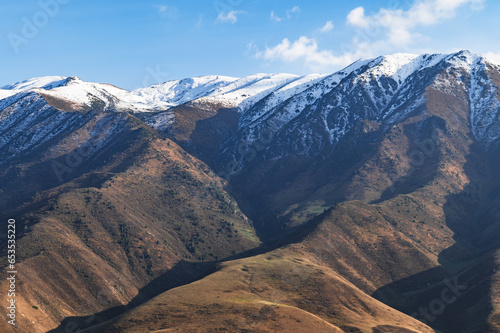 Mountain hills with snow-capped peaks and blue sky. Mountains of Kyrgyzstan.