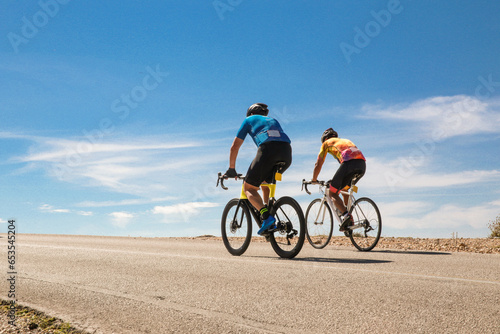 bike bikers race uphill on asphalt road team running