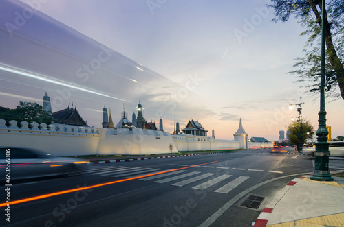 street view at grand royal palace of Bangkok with many traffic in long expossure light tail technique in sunset with beautiful vanila skytime.