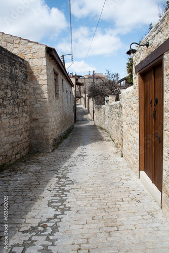 Stoned footpath crossing a traditional village. Stoned houses with wooden doors. Vintage architecture. Lofou village, Cyprus photo