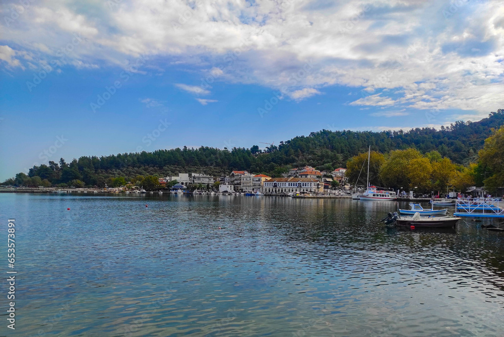Limenas City in Thassos Island , Greece , the main city of the island with the harbor and pier , and the pine forest behind