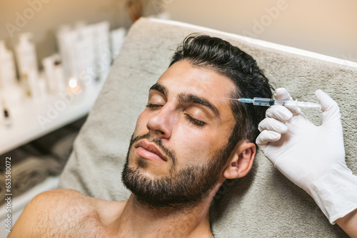 Calm man having botox rejuvenation procedure