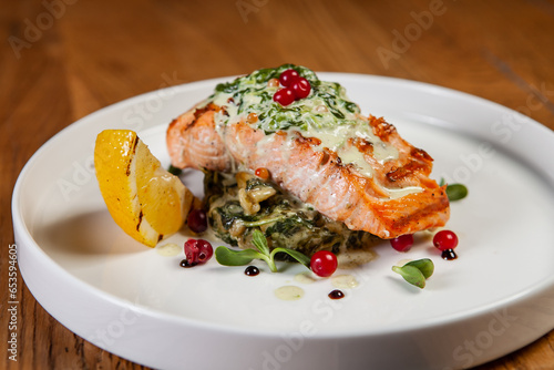 restaurant dish on a wooden table, salmon steak, spinach
