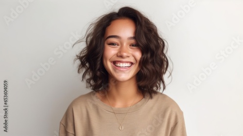 A teenage girl exuding confidence and happiness, framed by a pristine, well-lit studio environment. photo
