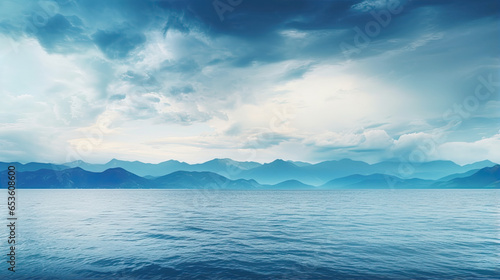 Blue-green clouds over the sea. Toned dark teal water and sky. Background with space for design. The mountains on the horizon. Calm  tranquility atmosphere. Wide banner. Webside header.