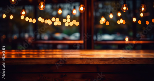 Top of wooden table on blur background with lights of bar, cafe, coffee shop or restaurant. Using for mock up template for display of your design © GustavsMD