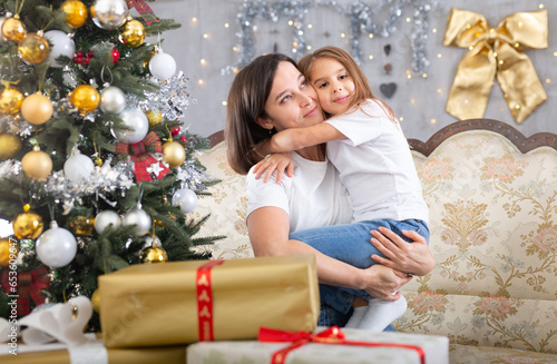 Mom and daughter hugging in Christmas interior